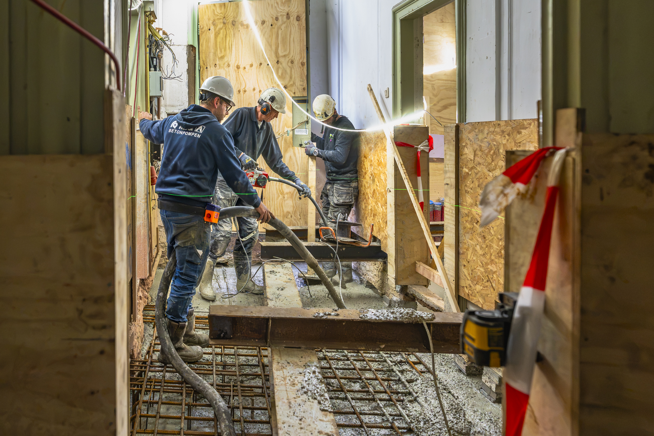 Medewerkers storten beton voor het funderingsherstel in het Westfries Museum