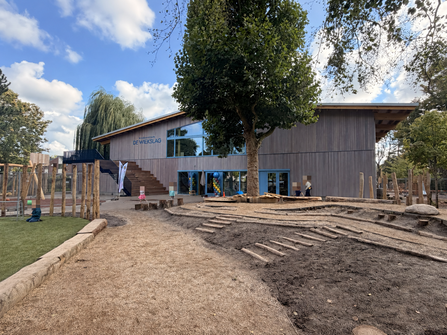 Natuurlijk speelplein met bomen en houten speeltoestellen bij Kindcentrum De Wiekslag in Bleiswijk